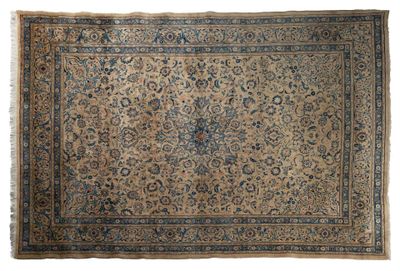 un tapis persan ancien aux couleurs bleues et beiges