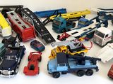 un grand nombre de voitures et de camions jouets qui se trouvent sur la table