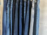 plusieurs paires de jeans bleus suspendues à un portant dans une pièce