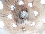 an overhead view of a wooden bowl with holes in it