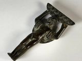une vieille figurine en bronze représentant un homme tenant un morceau de bois