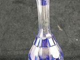 a blue glass decanter sitting on a black surface