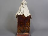 une image représentant une statue d'une femme assise sur une boîte