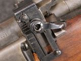 an old machine gun with a wooden handle on a wooden table