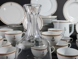 many cups and saucers and a decanter on the table