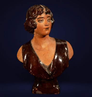 a brown busturine of a woman wearing a brown dress