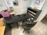 a desk with a chair and a book shelf in the corner