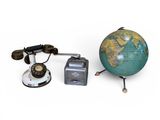 un petit globe terrestre posé à côté d'un appareil photo et d'autres objets