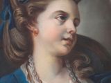 portrait of a young woman in a blue dress with a pearl necklace