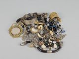a pile of assorted jewelry on a white surface