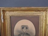 an old picture of a woman in a dress and hat in a gold frame