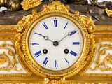 a gold and white clock with a statue on top of it