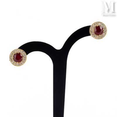 a close up of a pair of earrings on a black stand