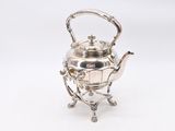 silver plated teapot on stand on white background
