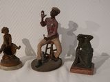 three figurines of a man sitting on a stool and a woman sitting on a stool