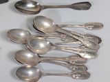 several silver spoons and spoon spoons sitting on a table