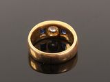 an image of a gold ring with a diamond and blue sapphires