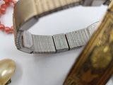 a bracelet and a watch on a table with pearls and beads