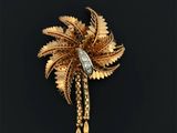 une image représentant une broche en or ornée d'un palmier