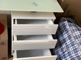 a white desk with four drawers in the middle of a room