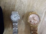 two watches sitting on a table next to each other