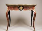 une table rouge et noire surmontée d'une tête de lion
