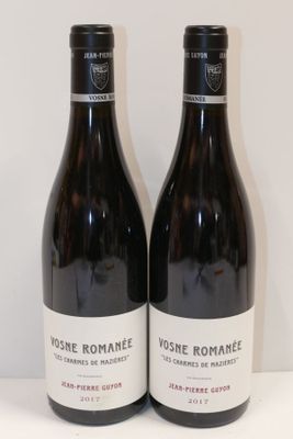 deux bouteilles de vin posées sur une table l'une à côté de l'autre