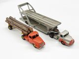 deux camions miniatures placés l'un à côté de l'autre sur une surface blanche