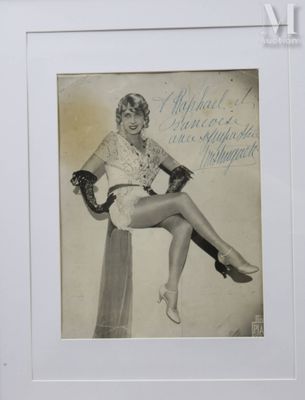 une vieille photo d'une femme assise sur une chaise, les jambes croisées