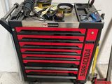 une boîte à outils posée dans un garage, avec des outils dessus
