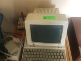 un petit ordinateur posé sur un bureau en bois