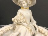 a figurine of a woman with a dog on a plate