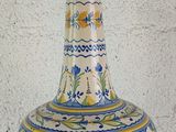a blue and yellow vase sitting on a white table