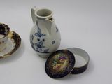 a small cup and saucer sitting next to a small tea pot