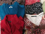 many sweaters laid out on a white surface