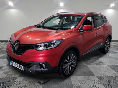 une voiture rouge garée dans un garage au sol en damier