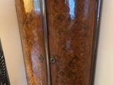 a tall wooden cabinet with a mirror on top of it