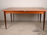 a wooden table with two leaves on it in a room