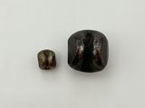 deux morceaux de pierre noire posés l'un à côté de l'autre sur une surface blanche