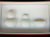 three white vases sitting in a box on a table