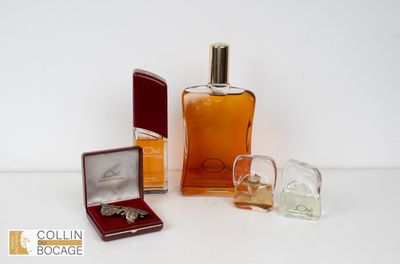 un flacon d'eau de Cologne à côté d'une boîte à bague et d'un coffret de parfum