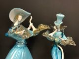 two blue glass figurines with hats on top of them