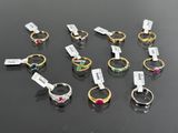 a group of rings with different colored stones on them sitting on a table