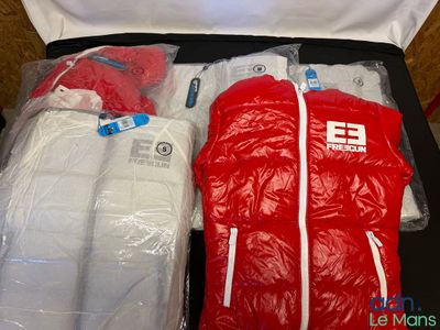 a suitcase filled with clothing and a bag of clothes