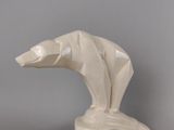 sculpture représentant un ours polaire posé sur un rocher, sur fond gris