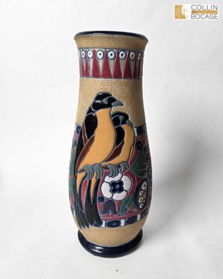 un vase orné d'un oiseau peint, posé sur une table