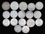 Plusieurs pièces d'argent sont disposées en cercle sur une surface noire