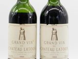 two bottles of wine sitting next to each other on a white surface