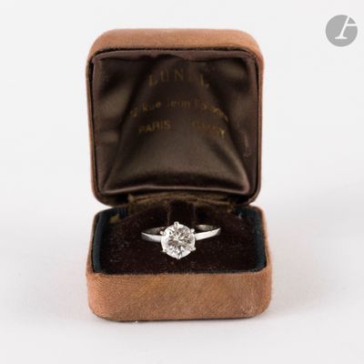 une bague en diamant dans un écrin en velours sur fond blanc