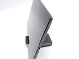 a laptop computer sitting on a stand on a white surface